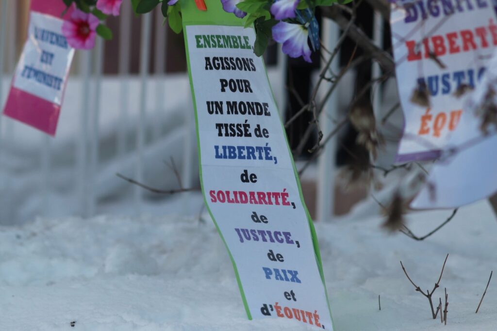 Pancarte accrochée sur le lieu du rassemblement: 
« Ensemble, agissons pour un monde tissé de Liberté, de Solidarité, de Justice, de Paix et d'Équité »
Crédit: Louis-Frédéric Verrault-Giroux, TROVEP Montréal